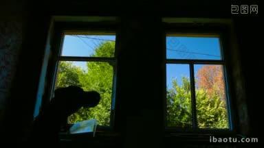 承包商在房子里<strong>安装</strong>了一扇新的窗户，窗外是明亮的树木和蓝天